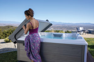 woman lifting hot tub cover